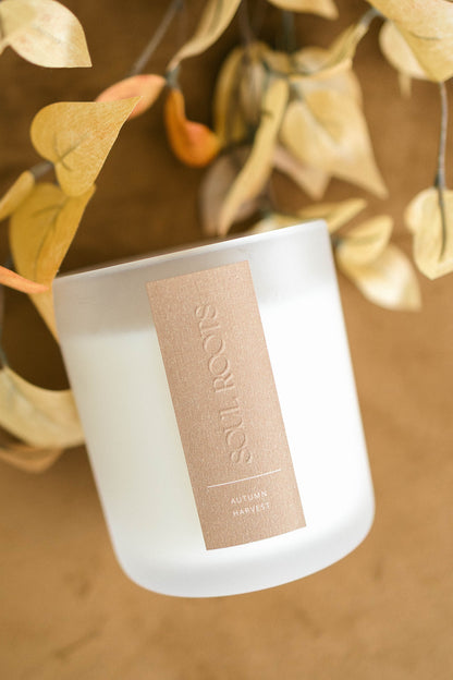 Luxury autumn candle styled with dried foliage